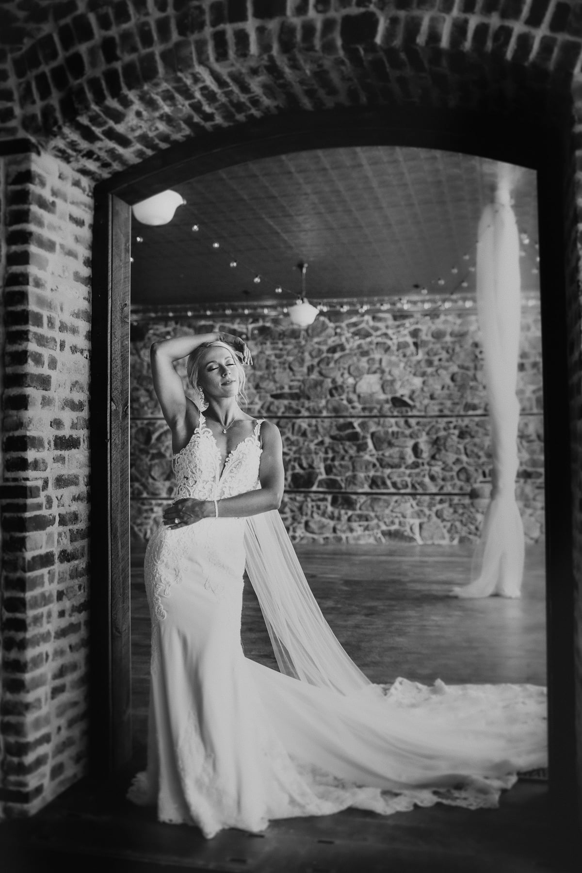 bride posing in brick archway