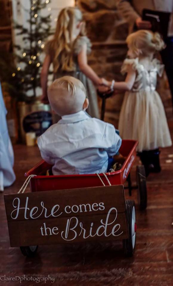 ring bearer in red wagon