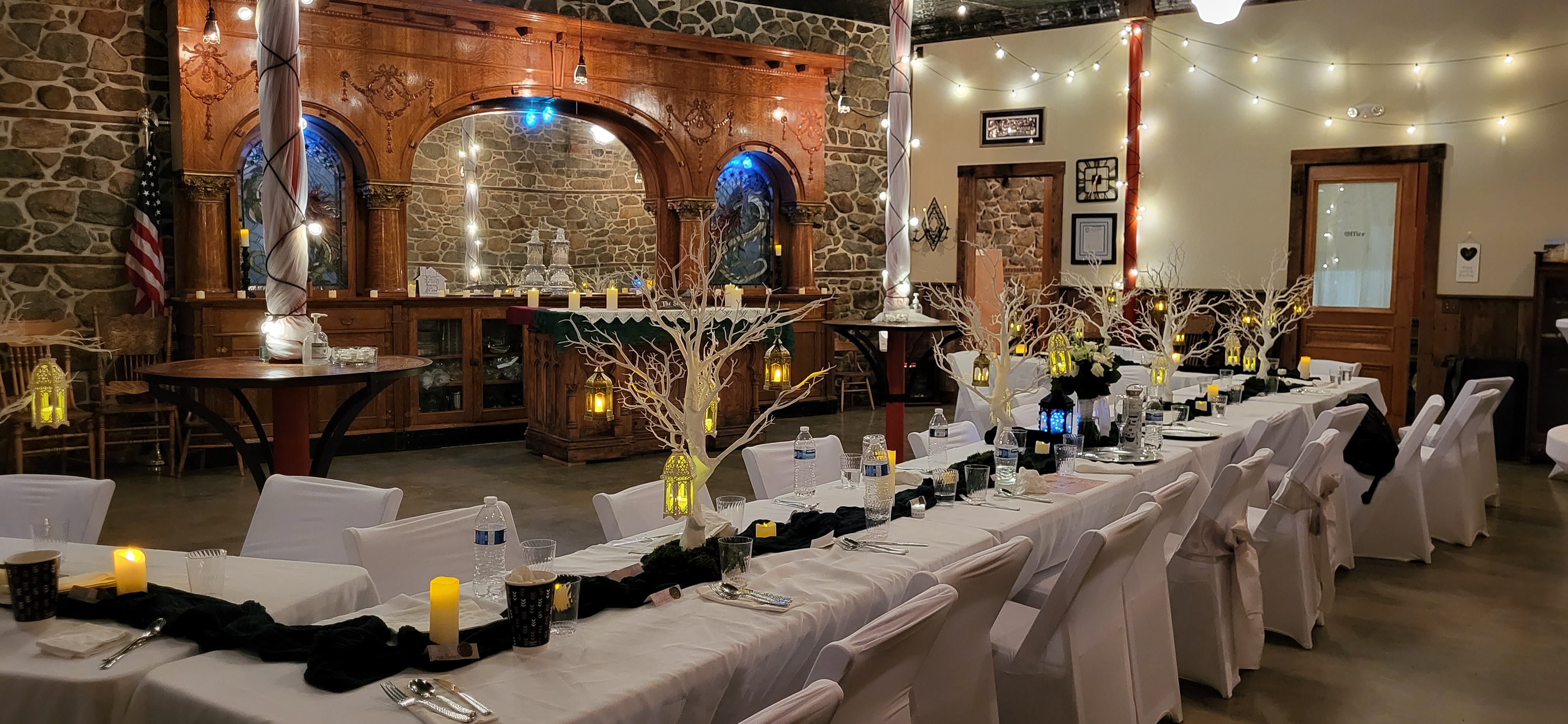 wedding reception tables set up around large historic wooden bar