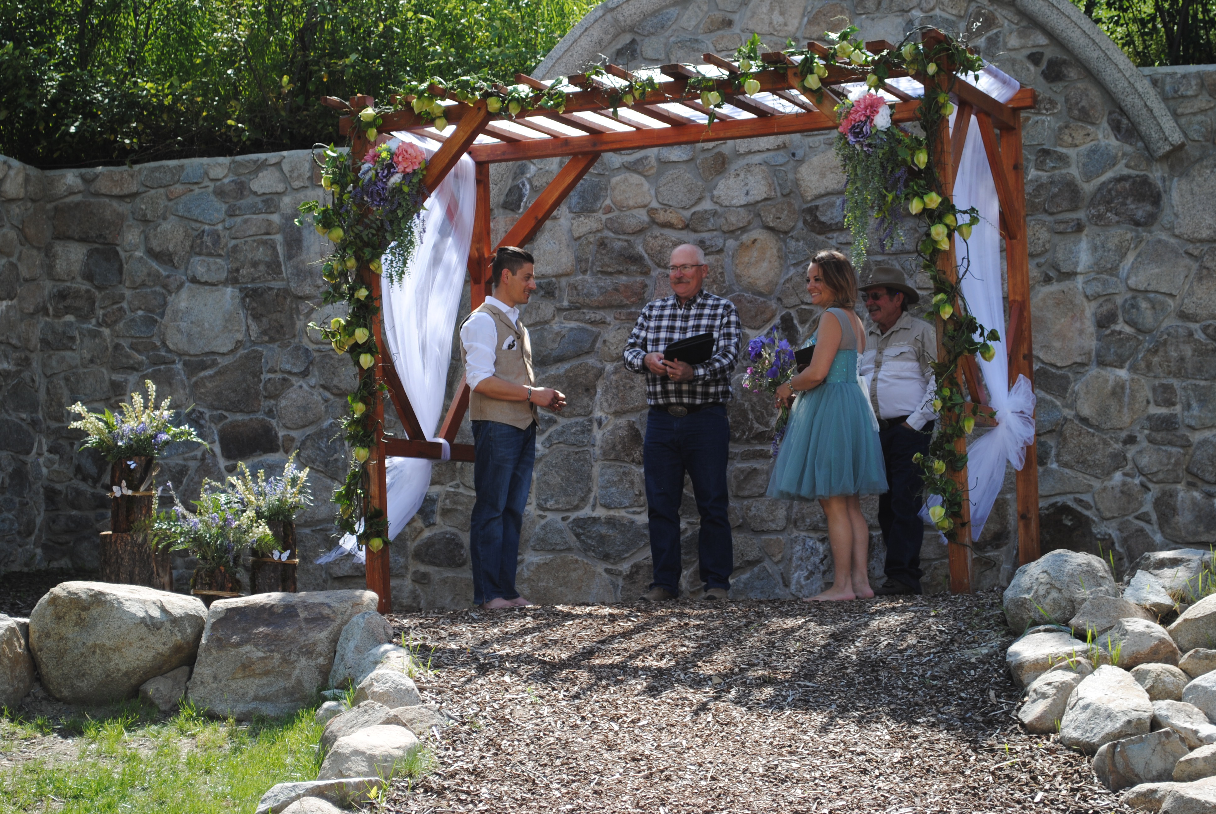 outdoor wedding ceremony under wooden arch
