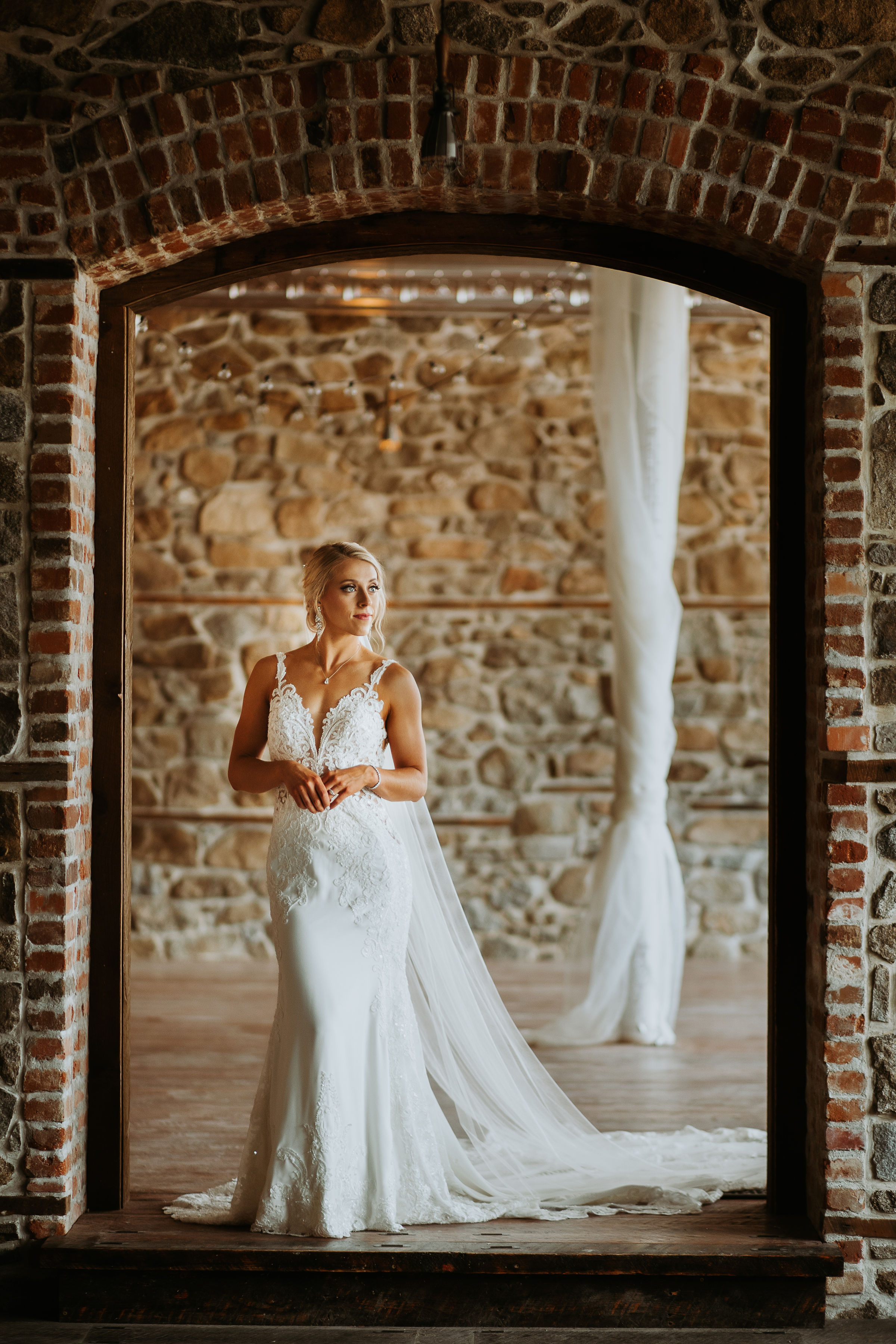 bride standing in brick archway