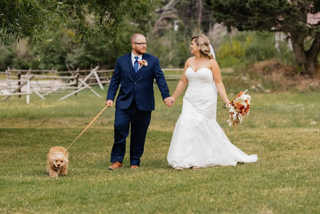 bride and groom walking their dog
